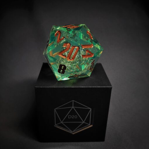 Green transparent dice with bubble inside and golden numbers standing on a black box with "D20" written on it.