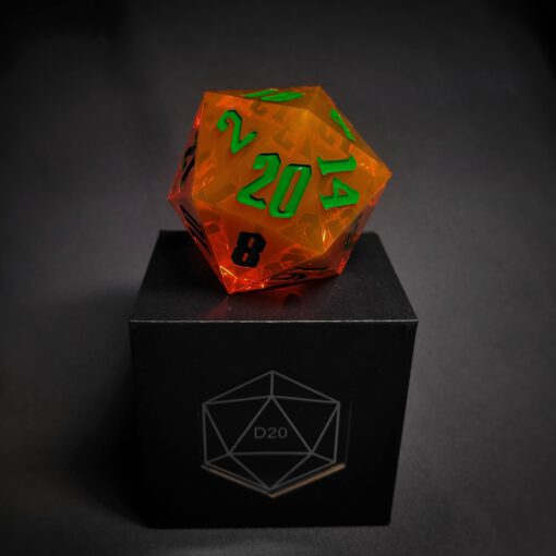 Orange transparent dice with green numbers standing on a black box with "D20" written on it.