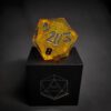 Yellow Transparent dice with bubble inside and silver numbers standing on a black box with "D20" written on it.