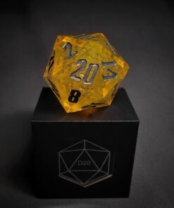 Yellow Transparent dice with bubble inside and silver numbers standing on a black box with 