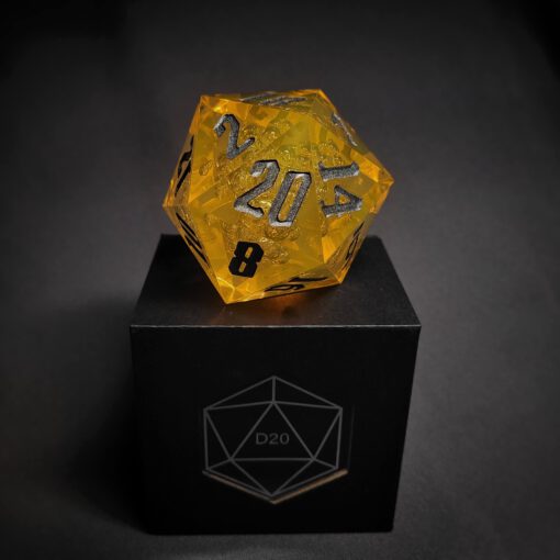 Yellow Transparent dice with bubble inside and silver numbers standing on a black box with "D20" written on it.
