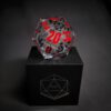 Transparent dice with bubbles inside and red and black numbers standing on a black box with "D20" written on it.