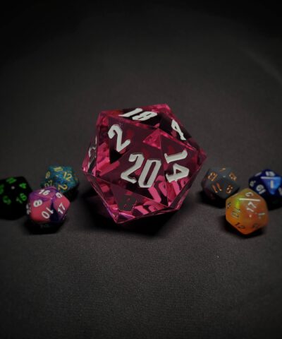 An extra large pink transparent d20 die with white numbers sitting in the middle of 6 smaller d20 dice.