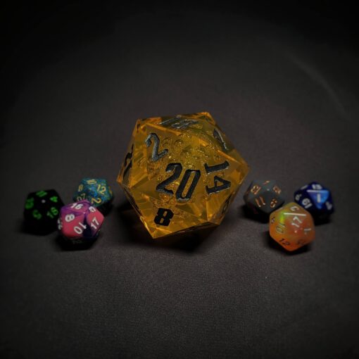 An extra large yellow transparent d20 die with silver numbers sitting in the middle of 6 smaller d20 dice.