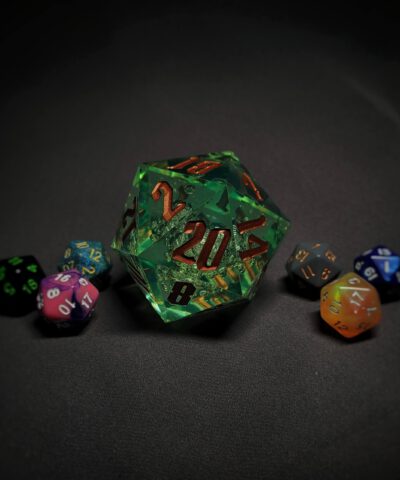An extra large green transparent d20 die with golden numbers sitting in the middle of 6 smaller d20 dice.